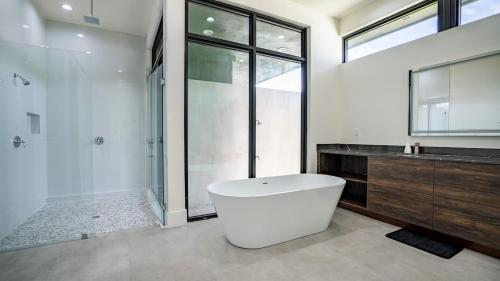 a bathroom with a large white tub and a shower at The Mansion One and Only Luxurios 8 000 ft Villa in Melalevca Isles