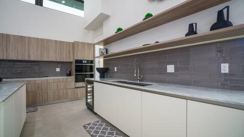 a large kitchen with a sink and a counter at The Mansion One and Only Luxurios 8 000 ft Villa in Melalevca Isles