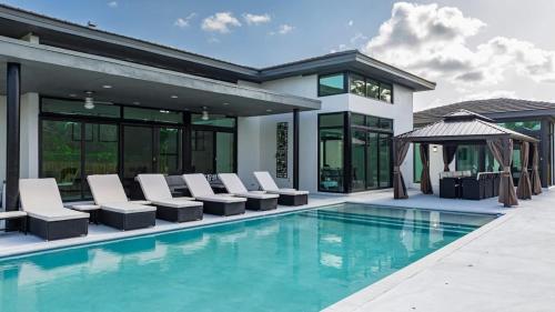 a house with a pool with chairs and a gazebo at The Mansion One and Only Luxurios 8 000 ft Villa in Melalevca Isles