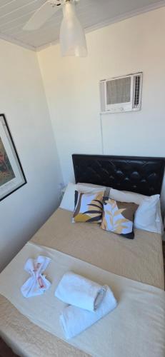 a bedroom with a bed with towels and a fan at Pousada Mar Dos Anjos in Arraial do Cabo
