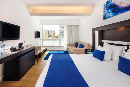a hotel room with a large bed and a tv at Jupiter Algarve Hotel - Beach & Spa in Portimão