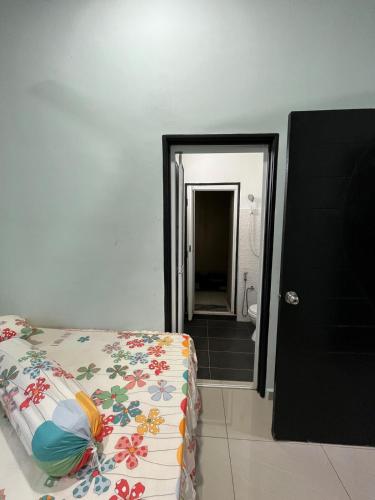 a bedroom with a bed and a bathroom with a shower at CozyInn Homestay 4 in Kampong Lanjut Manis