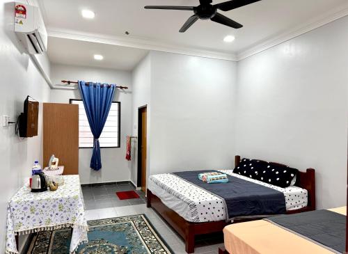 a bedroom with two beds and a ceiling fan at AL-REZQI RoomStay in Marang