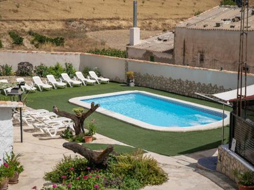 einen Pool auf einem Gebäude mit Stühlen in der Unterkunft CORTIJO EL PRADO ll in Castril