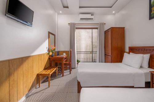 a hotel room with two beds and a television at Sala Hoi An Hotel in Hoi An