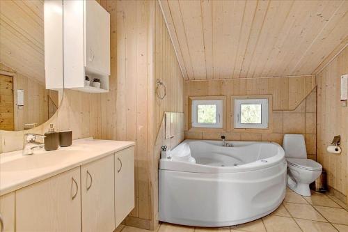 um banheiro com uma banheira branca e um vaso sanitário em JB699-Fjerritslev-Revlingestien-43 em Torup Strand