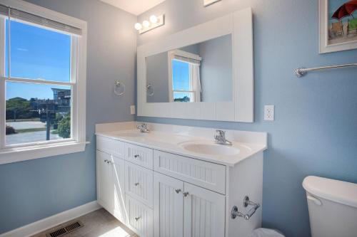 a white bathroom with a sink and a mirror at 3054 - Latitude Adjustment in Southern Shores
