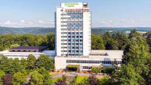 a tall white building with a sign on it at Wyndham Garden Lahnstein Koblenz in Koblenz
