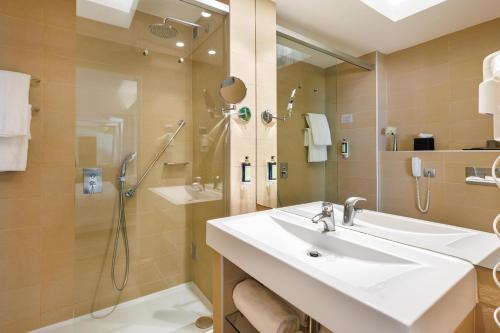 a bathroom with a sink and a shower at Jupiter Algarve Hotel - Beach & Spa in Portimão