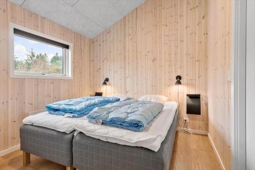 ein Schlafzimmer mit einem Bett mit blauen Kissen darauf in der Unterkunft JB164 Fjerritslev - Poppelvej 16 in Fjerritslev