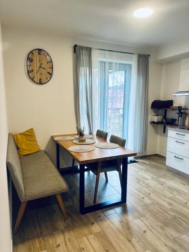 a dining room with a table and a clock on the wall at Apartmány pod Suchým vrchem in Stachy