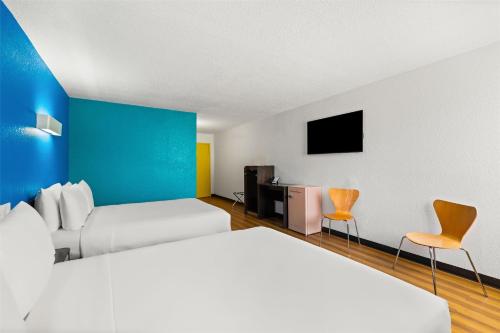 a hotel room with two beds and a tv at Signature Inn Miami in Miami