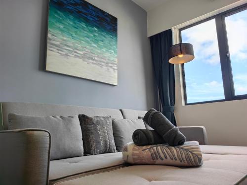 a living room with a couch with a pillow at Vetro11 Beside QEH1 by JUNE Homestay in Kota Kinabalu