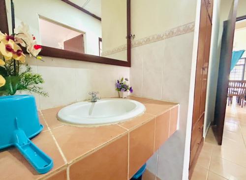 a bathroom with a sink and a mirror at The 5R Famosa Villa in Kampong Ulu Pegoh