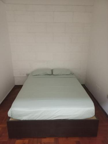 a bed in a small room with a white wall at Maryhouse2 in Lomas de Zamora
