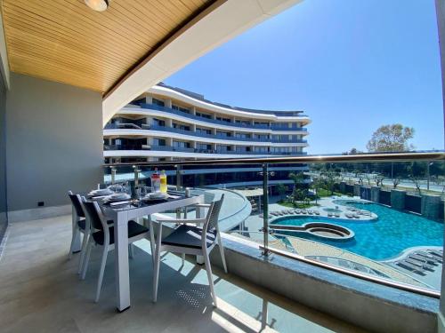 a balcony with a table and chairs and a pool at Via Mar Residence - Alanya Experience in Alanya
