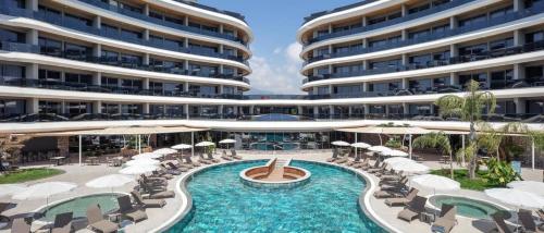 a resort with a swimming pool with chairs and umbrellas at Via Mar Residence - Alanya Experience in Alanya