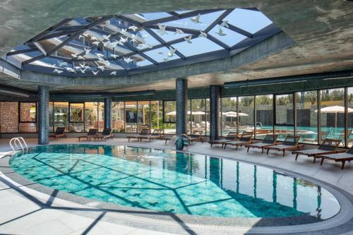 a pool in a building with a large glass ceiling at Via Mar Residence - Alanya Experience in Alanya