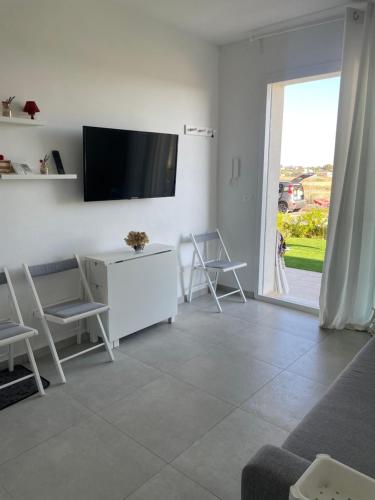 a living room with a tv on a white wall at Ortensia Apartment in Pachino