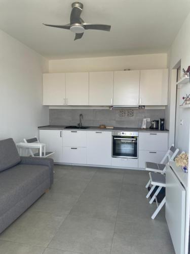 a living room with a couch and a kitchen at Ortensia Apartment in Pachino