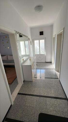 a white room with a desk and a hallway at Apartman Centar comfort in Posušje