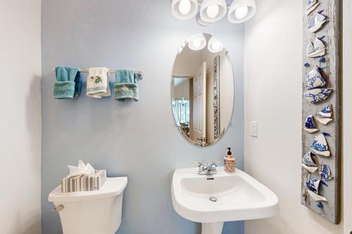 a white bathroom with a sink and a mirror at Bear Trap Dunes - 51 Tulip Poplar in Ocean View