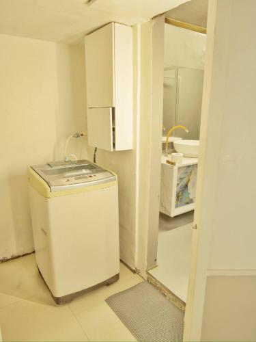 a small kitchen with a washer and a sink at Clear Mountains Properties in Kharakvasla