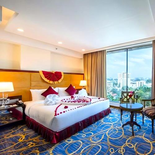 a hotel room with a bed and a large window at Grand Palace Hotel & Resort Sylhet in Sylhet
