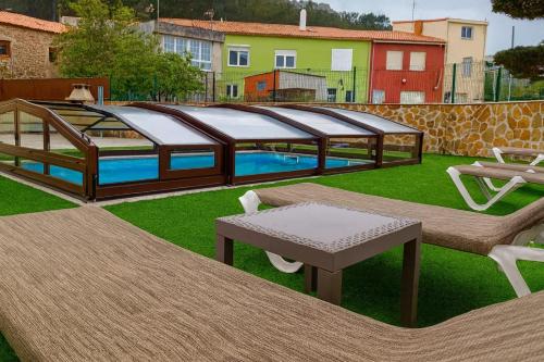 a swimming pool with a gazebo in a yard at Casa El Rincón de Alberto con Piscina CLIMATIZADA y Calefacción in Camelle