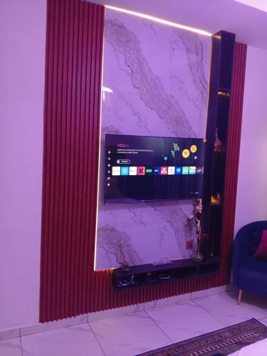 a large flat screen tv sitting on a wall at Peace Dew Apartments in Maiyegun