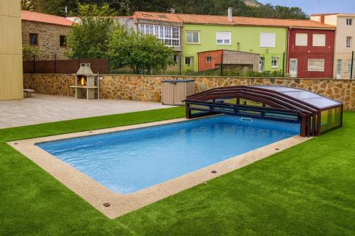 a swimming pool in the yard of a house at Casa El Rincón de Alberto con Piscina CLIMATIZADA y Calefacción in Camelle