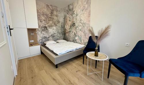 Un dormitorio con una cama y dos sillas y una mesa. en Apartament Uroczy w Szczyrku na stoku, en Szczyrk
