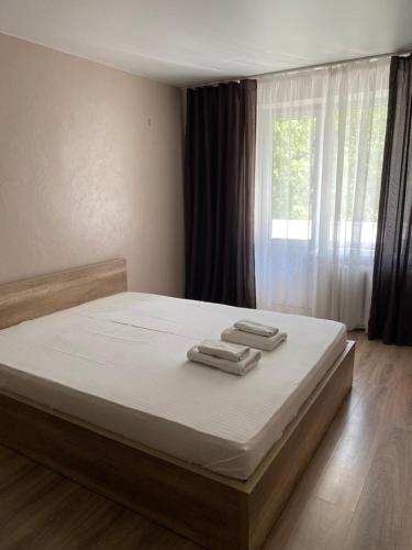 a bedroom with a bed with two towels on it at Апарт Безручка in Rivne