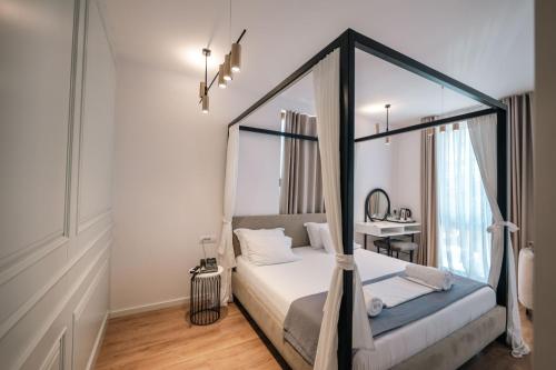 a bedroom with a canopy bed and a desk at Sharm Hotel Luxury in Gjirokastër