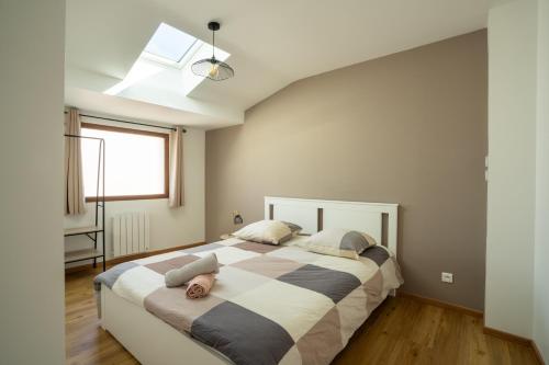 ein Schlafzimmer mit einem großen Bett mit einem großen Fenster in der Unterkunft Les Maisons Bareyre - Grandes Maisons avec terrasse in Saint-Sandoux