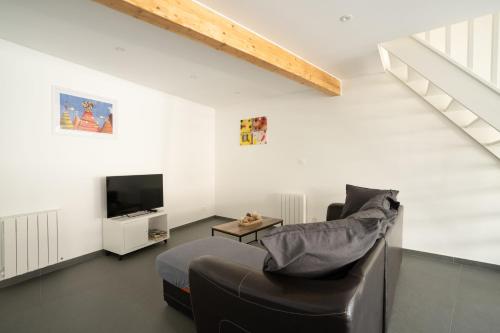 ein Wohnzimmer mit Sofa und Fernseher in der Unterkunft Les Maisons Bareyre - Grandes Maisons avec terrasse in Saint-Sandoux