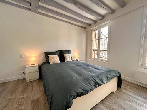 Un dormitorio con una cama grande y dos mesitas de noche. en Évasion sur la rivière - 4 pers - Centre, en Moret-sur-Loing