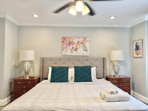a bedroom with a bed with a ceiling fan and two lamps at Atlanta Downtown Onsite Parking King! 3BR LM 06 Units in Atlanta