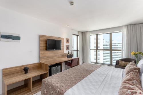 a hotel room with a bed and a television at HY Apartaments & Hotels-Boa Viagem in Recife