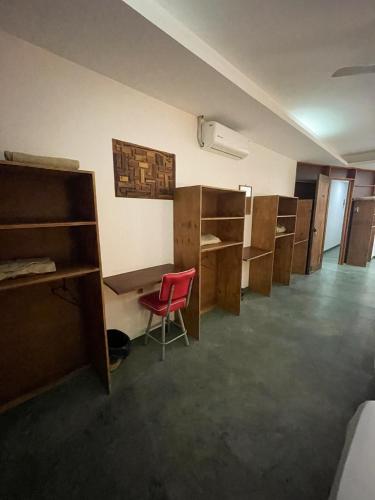 an empty room with bunk beds and a red chair at Madre Tierra Hostal in Puerto Escondido
