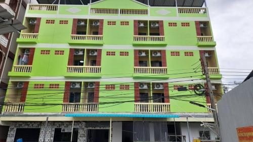 a green building with windows and balconies at Natcha Place Klongluang 35 in Ban Bang Khan