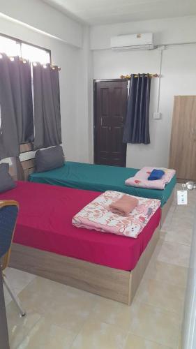 a room with two beds in a room at Natcha Place Klongluang 35 in Ban Bang Khan