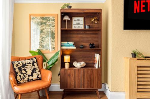 a living room with a chair and a book shelf at Rosewick Villa wt Office, Garden & Free Parking in Nottingham