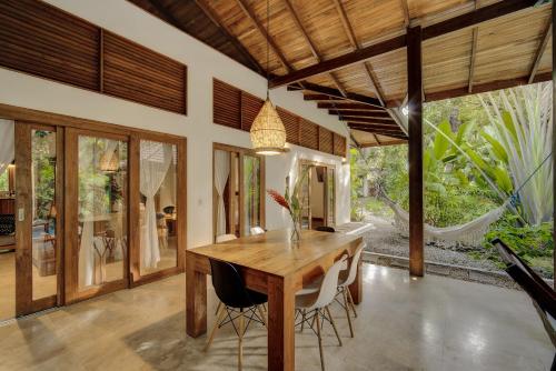 a dining room with a wooden table and chairs at ZEN Villa in Punta Uva