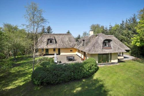 a large house with a thatched roof in a field at JB186-Fjerritslev-Gyvelstien-27 in Torup Strand