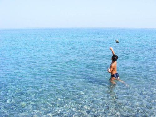 a man playing with a ball in the ocean at Nina's house 1 a 300 metri dal mare in Santa Caterina Dello Ionio Marina