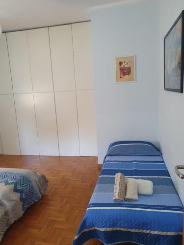 a bedroom with two beds with blue sheets at Laura's RHome in Rome