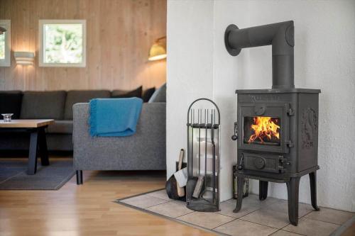a living room with a stove in a room at JB293-Fjerritslev-Tyttebaerstien-24 in Torup Strand