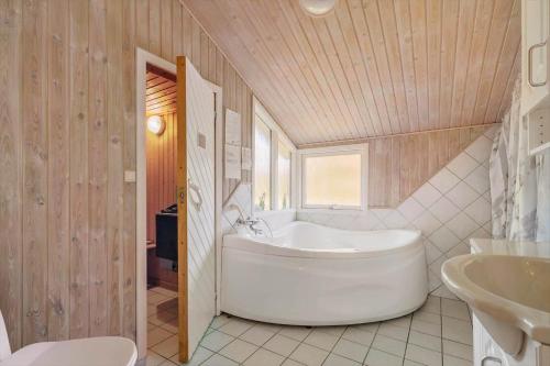 a bathroom with a large tub and a sink at JB293-Fjerritslev-Tyttebaerstien-24 in Torup Strand