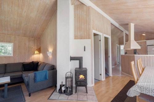 a living room with a couch and a stove at JB293-Fjerritslev-Tyttebaerstien-24 in Torup Strand